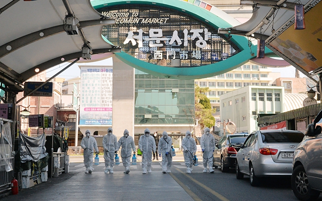 23日在韩国大邱，受疫情影响而临时休业的商家工作人员在西门市场进行防疫消毒。